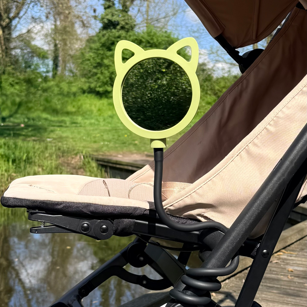 green cat shaped mirror attached to a stroller