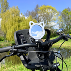 Bicycle handlebar with a cat-shaped mirror in a park setting