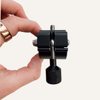 Hand holding a black bicycle mount against a white background